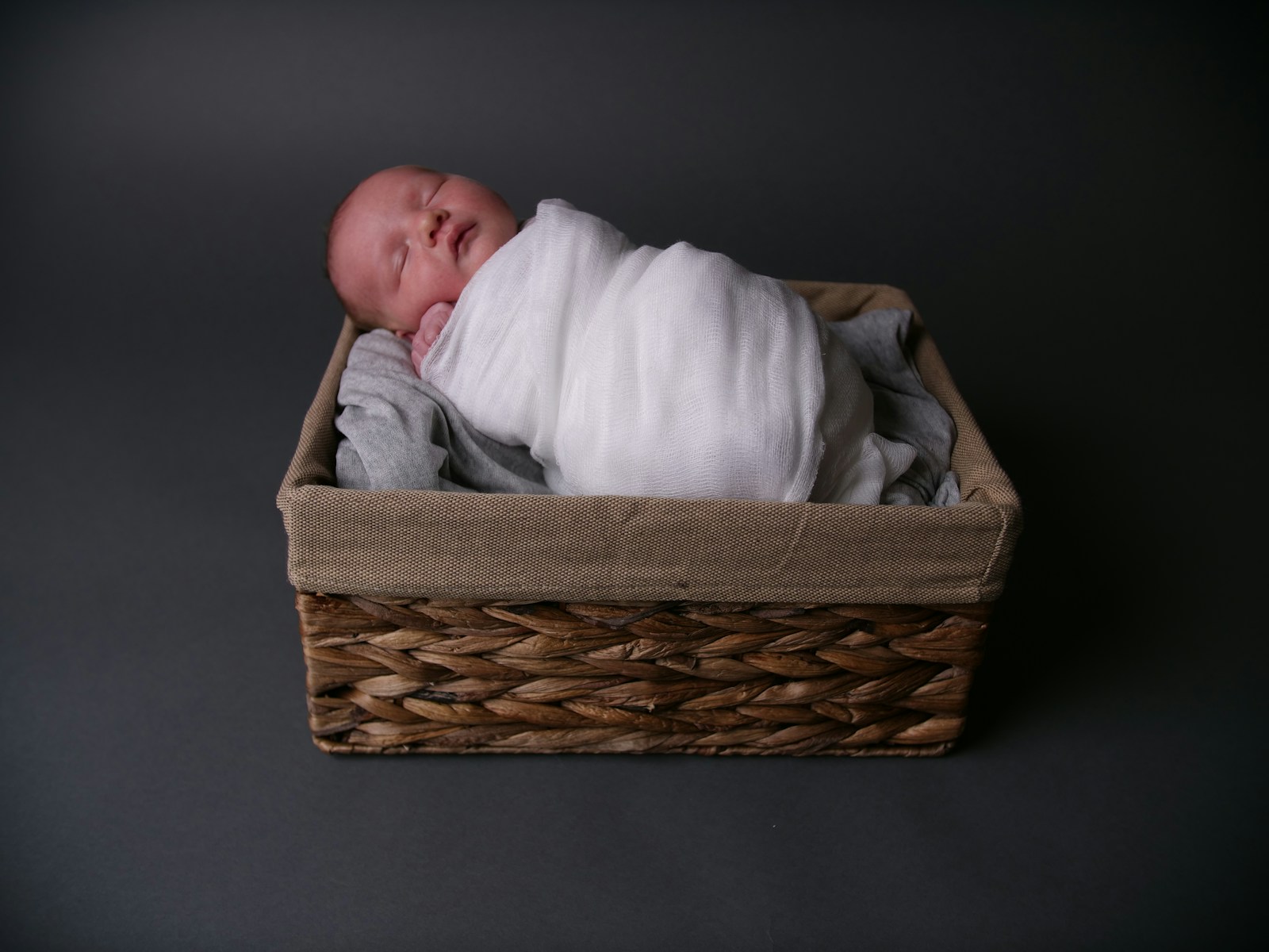 Sleeping newborn in a woven basket